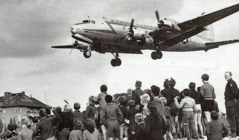 Residents of West Berlin watch as a US Air Force Douglas C-54 Skymaster lands at Tempelhof Airport. (US Air Force)